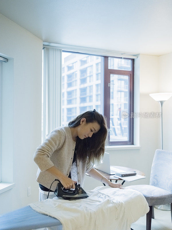 女人在家里熨衣服