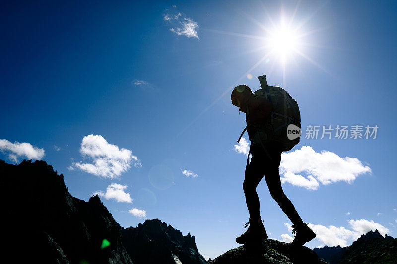 女人的剪影与背包徒步在日出的山顶