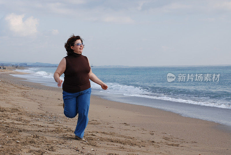 在海滩上跑步的成熟女人