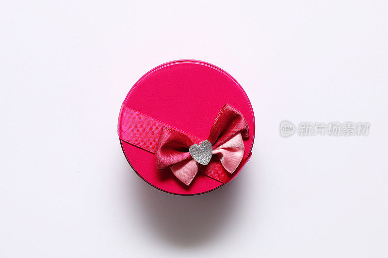 白色背景上带蝴蝶结的粉红色小礼品圆盒