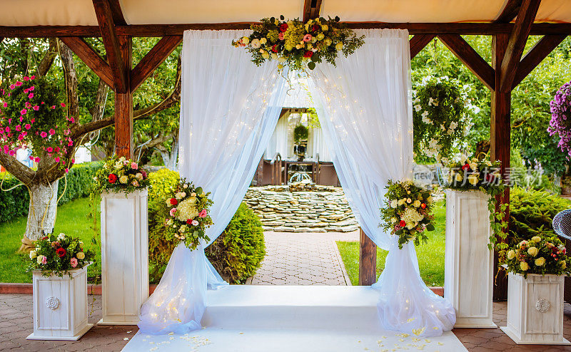 美丽的婚礼拱门，为婚礼仪式在花园里在阳光明媚的天气。