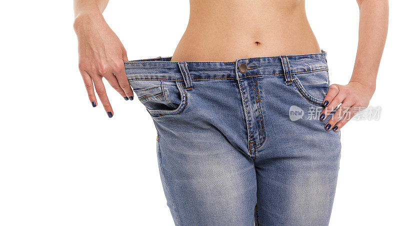 女人显示她减肥了。大的牛仔裤。