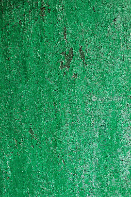 木质板的纹理呈绿色。草皮表面的绿色油漆开裂了