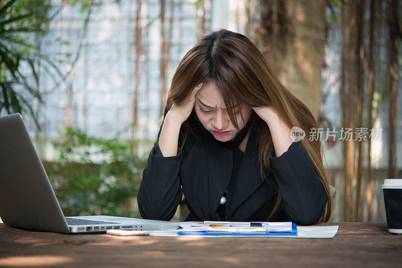 一个压力重重的职场女性的肖像。她正在看当前的文件报告，对结果不满意。