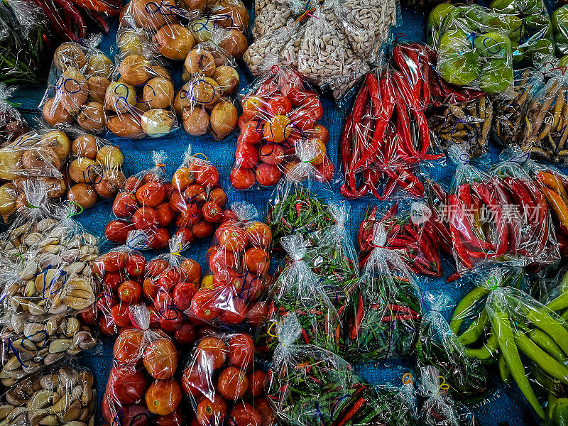 在泰国清迈省的一个当地乡村市场，新鲜的泰国蔬菜装在塑料袋中展出。