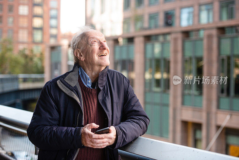 在美国纽约户外用手机发短信的高级男子