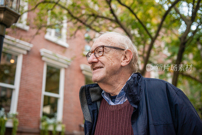 在纽约曼哈顿切尔西社区散步的微笑老人
