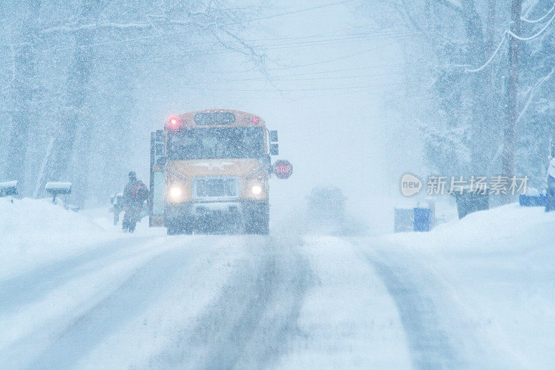 孩子学生在暴风雪中跑向校车