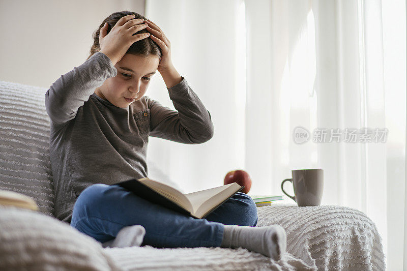 一个十几岁的女孩在客厅看书