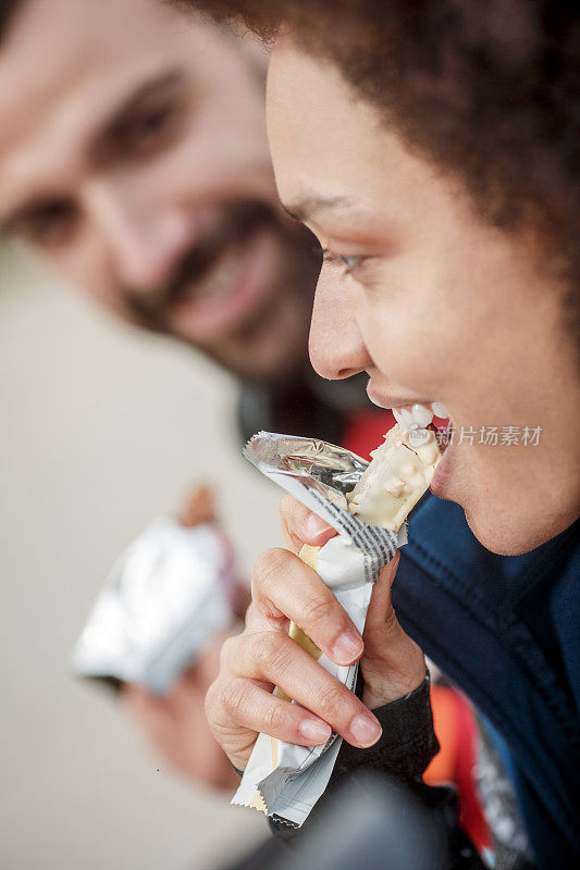 活跃的年轻女子正在吃蛋白质零食棒