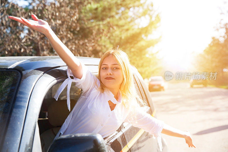 快乐的女人看着车窗外的自然夏天