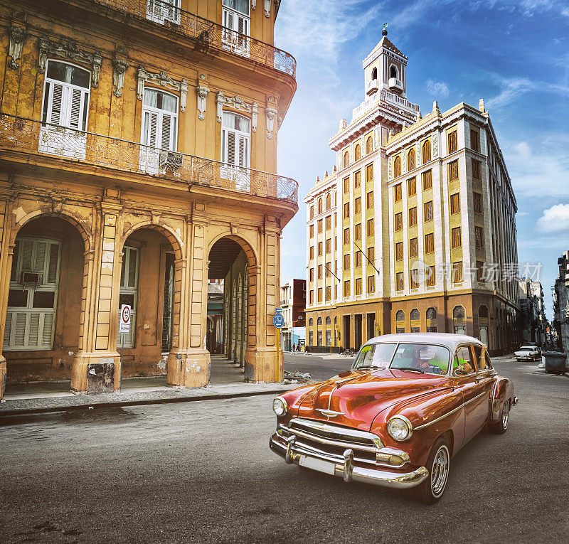 老式橙色老爷车行驶在古巴哈瓦那老城区
