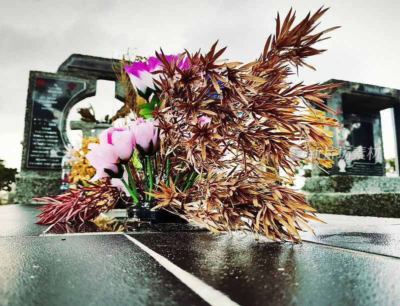 在墓地的坟墓上有鲜花和干花