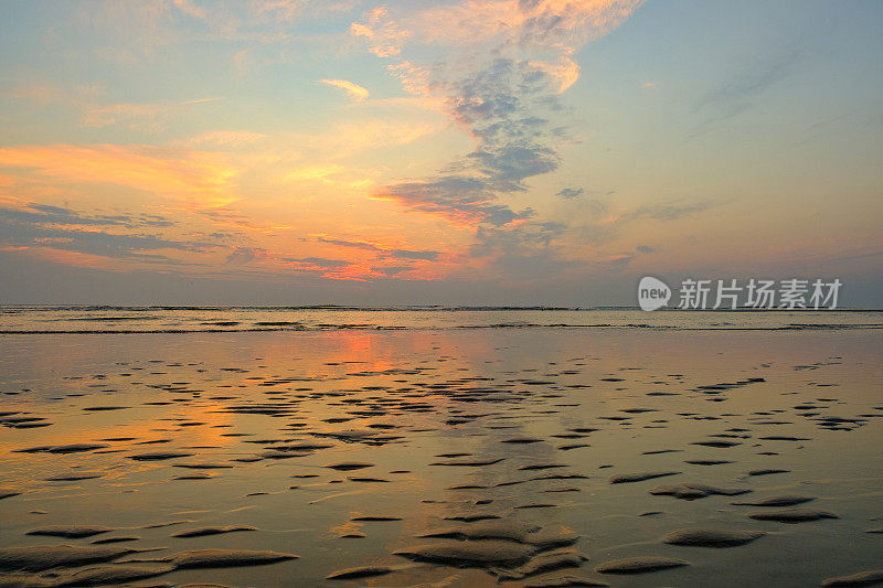 夏日海滩上的日落，海面平静