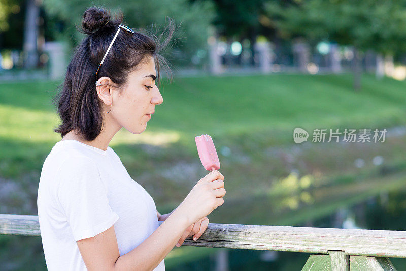 年轻女子在户外吃冰淇淋