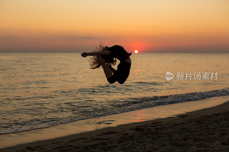 日落时分，女孩在海滩上跳舞