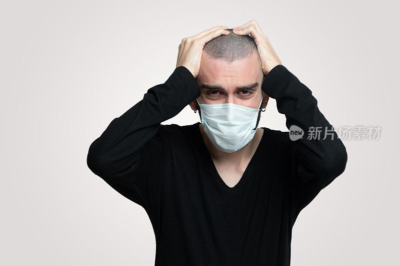 一名年轻人感染了冠状病毒，他头痛，他戴着口罩