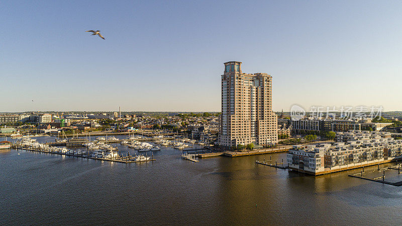 美国马里兰州巴尔的摩市帕塔普斯科河港景住宅区和码头的鸟瞰图，日落时分。