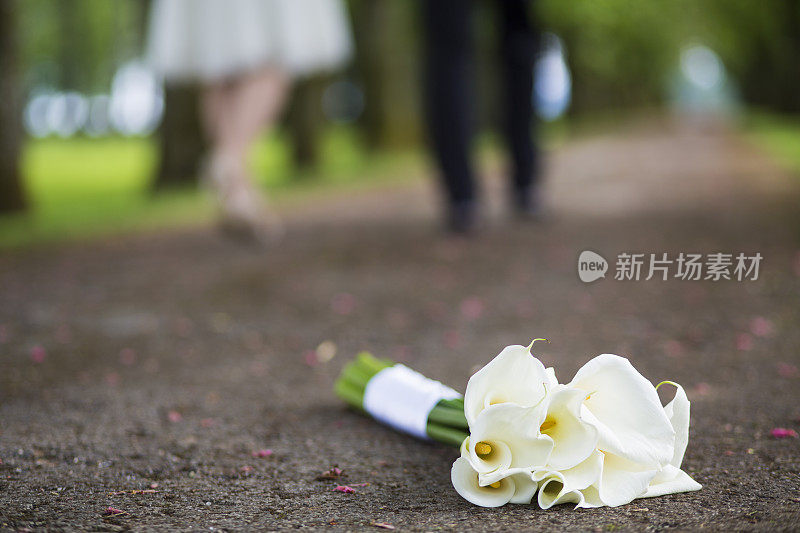 婚礼花束躺在地上，新婚夫妇离开
