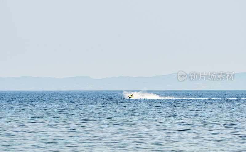 希腊哈尔基迪基，在爱琴海的吉拉基尼湾驾驶摩托艇的男人们。