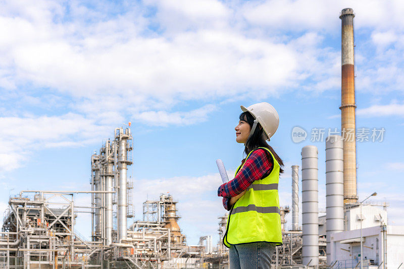 亚洲女工程师工作控制发电厂，能源工业，制造炼油厂。工程检查工厂图纸。