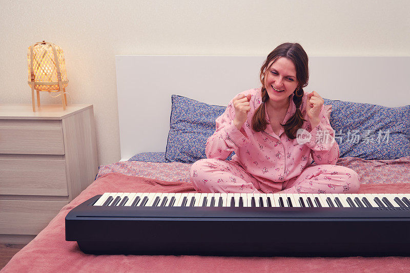 女人享受着在家里的卧室里成功地弹钢琴，享受着音乐家的狂喜