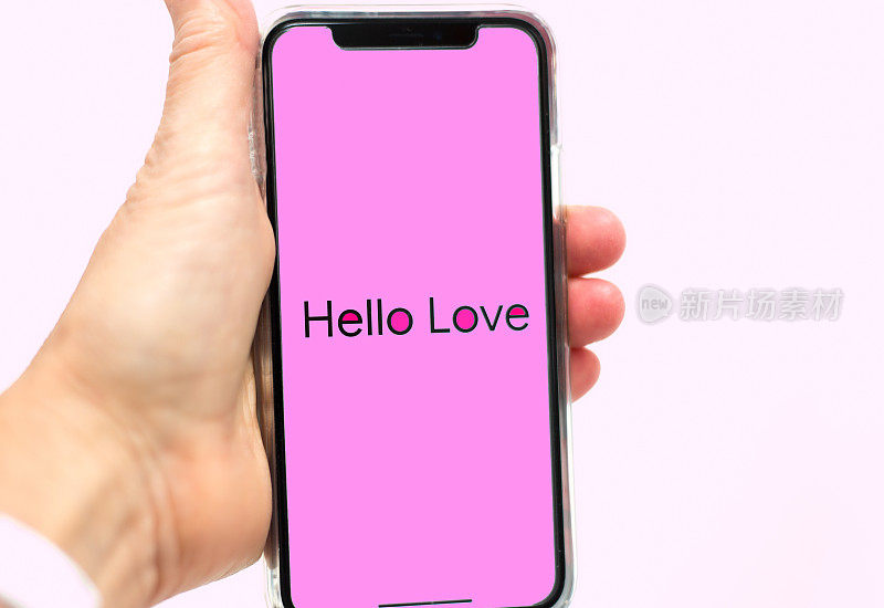 手握智能手机粉色短信:你好，爱