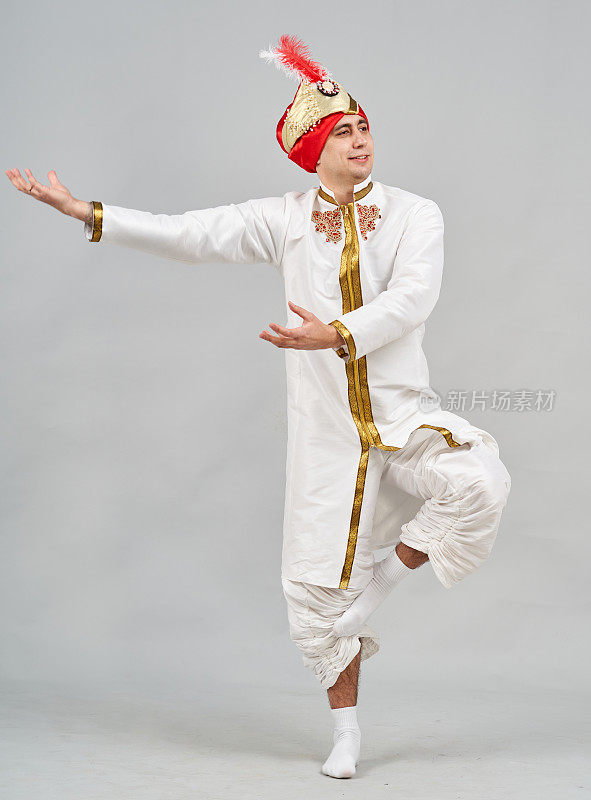 可爱的男人穿着喜庆的印度民族服装表演传统舞蹈