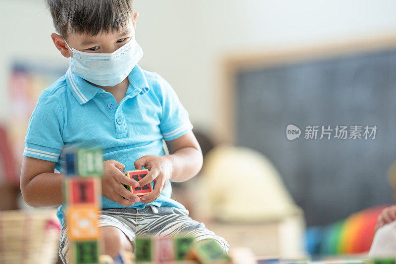 幼儿园男孩戴着面具在教室里的照片