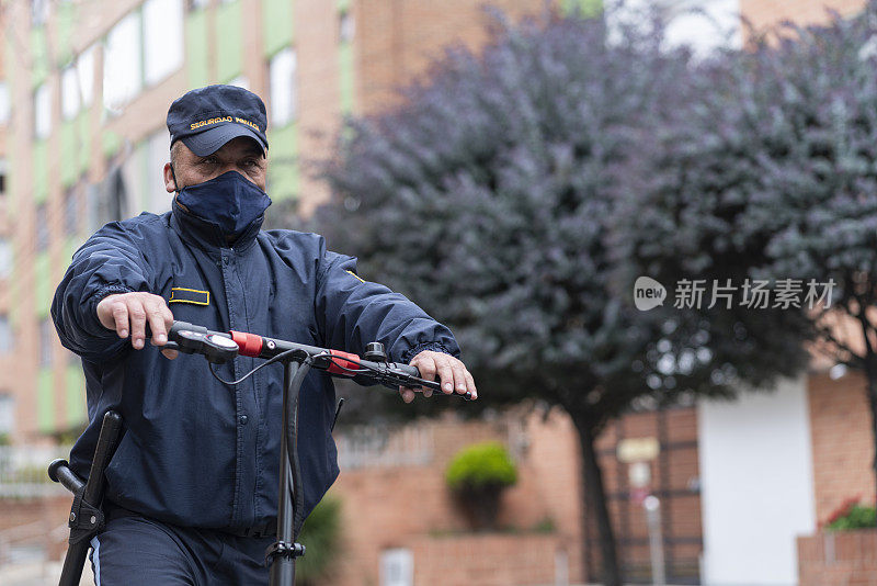 一名身穿蓝色制服的拉丁裔保安在大楼入口处踩着电动滑板进行巡视