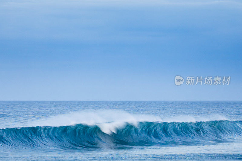 一个波浪在海岸附近破浪而出。