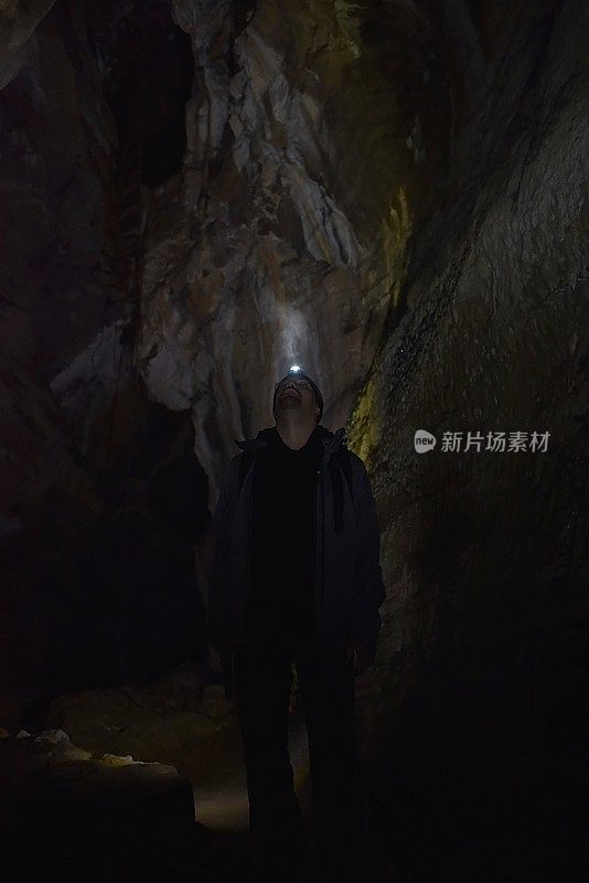 一名男性徒步旅行者正在探索一个黑暗的洞穴。斯洛伐克旅游目的地