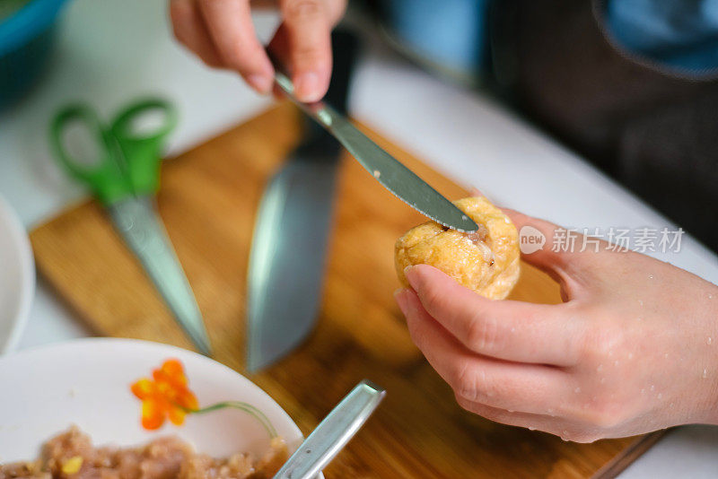 客厅里把肉涂进豆腐泡的女人的特写