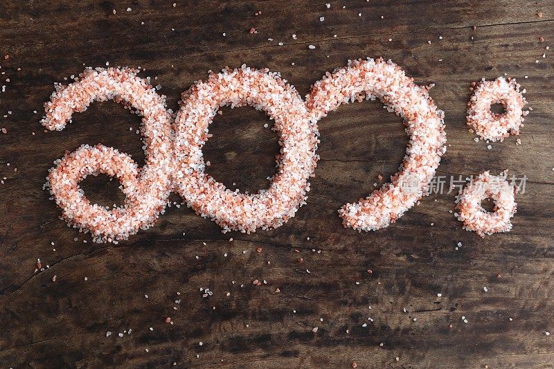 缅甸语中盐的意思，用粉红色的岩盐写在一张质朴的木桌上