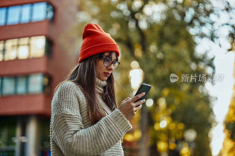 一个女人在户外查看她的手机是否有新信息