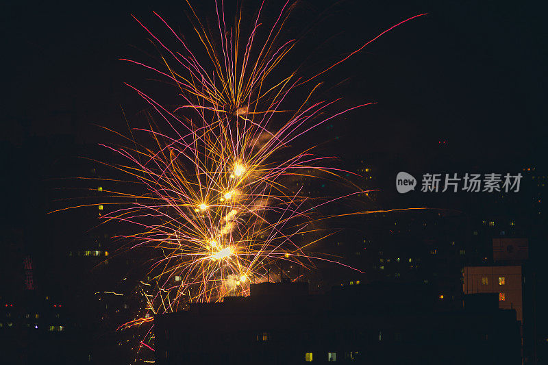 夜城的烟花。多色爆炸。庆祝节日的鞭炮在城镇剪影矢量背景