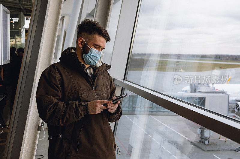 一名男性旅客在机场手持国际疫苗接种证书