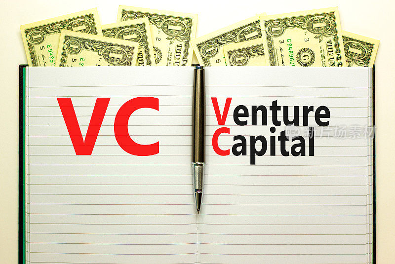 VC(风险投资)简称。概念词VC风险投资。金属笔。美元钞票。美丽的白色背景。副本的空间。商业和风险投资概念。