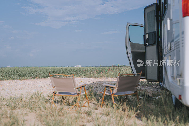 早上稻田旁停着的露营车旁有两把露营椅