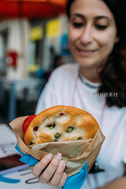 吃佛卡夏三明治加香蒜沙司和番茄的女人