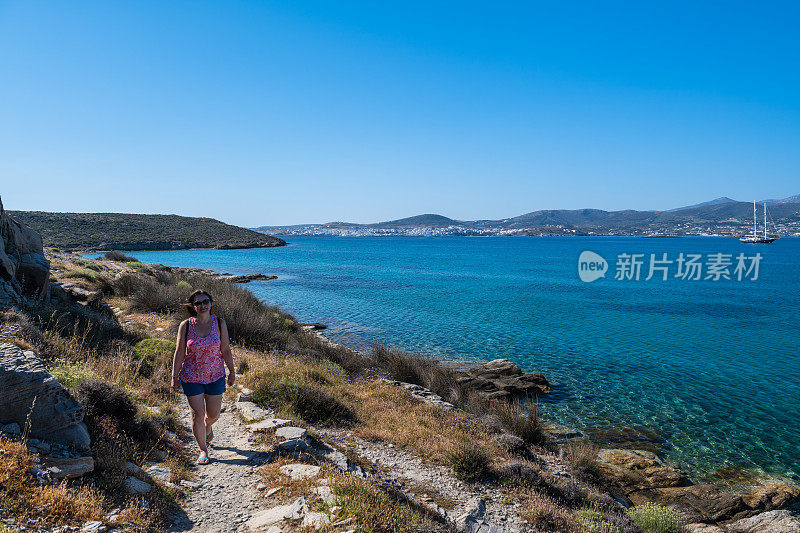 女旅行者从多石的地方眺望大海