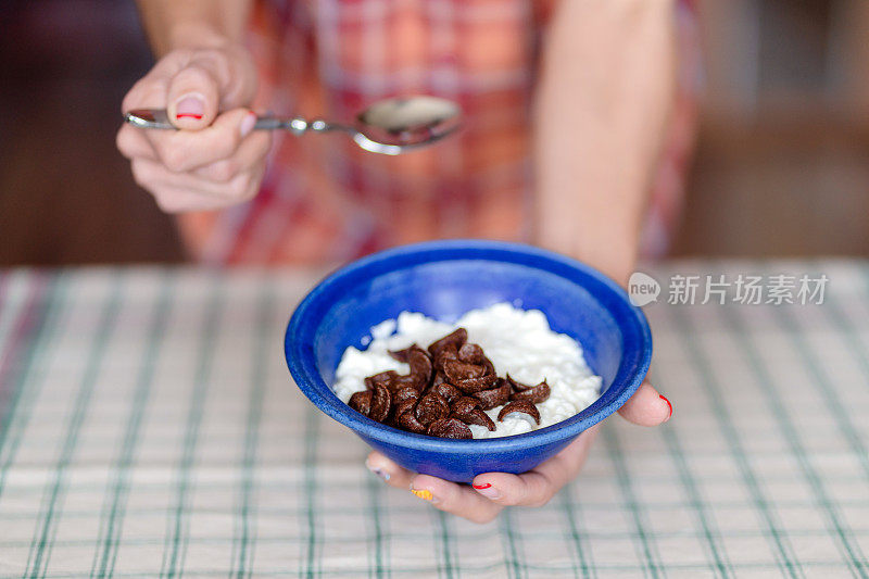 女人的手与什锦麦片碗的特写。健康的零食或早餐。