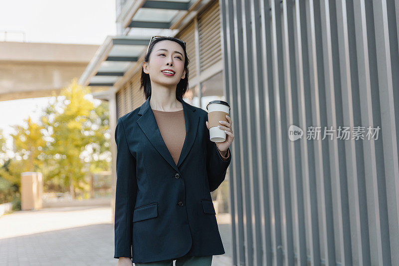 成功的女经理走在城市的街道上。