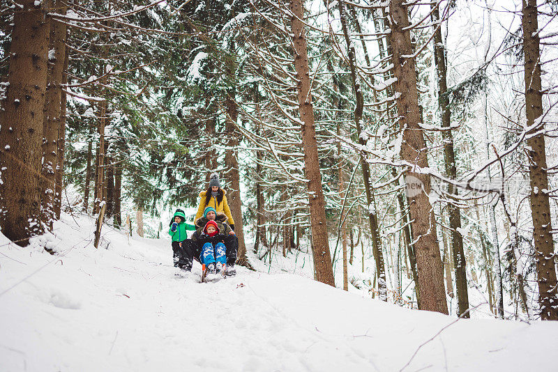 一家人带着两个孩子在雪地里享受美好的一天