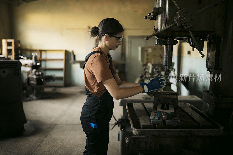 女工在她的金属车间里操作钻床