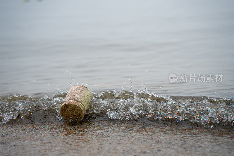 废弃的塑料容器被海浪冲到海滩上。