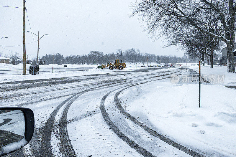 雪地停车场的轮胎痕迹和前装载机扫雪机