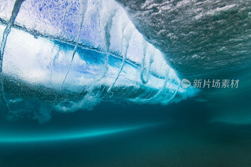 在清澈的海水中，海浪拍打着沙滩，水下的景色一览无余