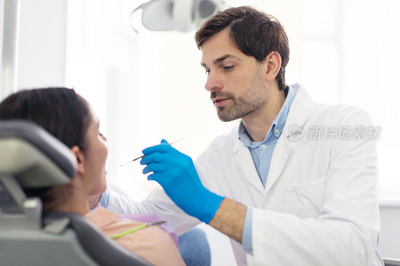在现代牙科诊所，专业的男牙医为女病人定期检查