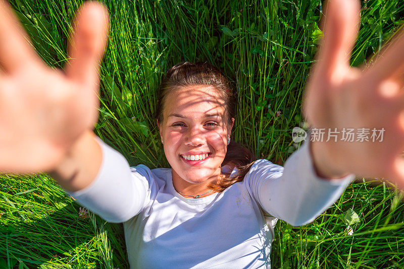 躺在草地上的快乐年轻女人